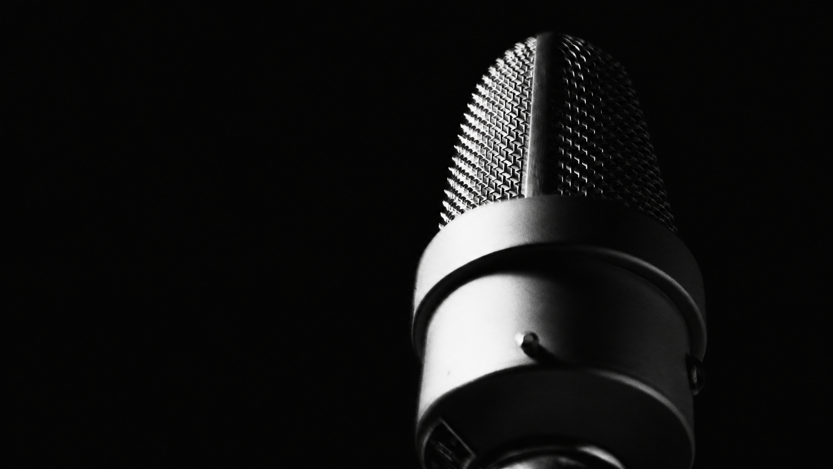 Studio microphone against a black background.